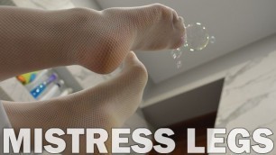Legs in White Fishnet Stockings Plays with Soap Bubbles